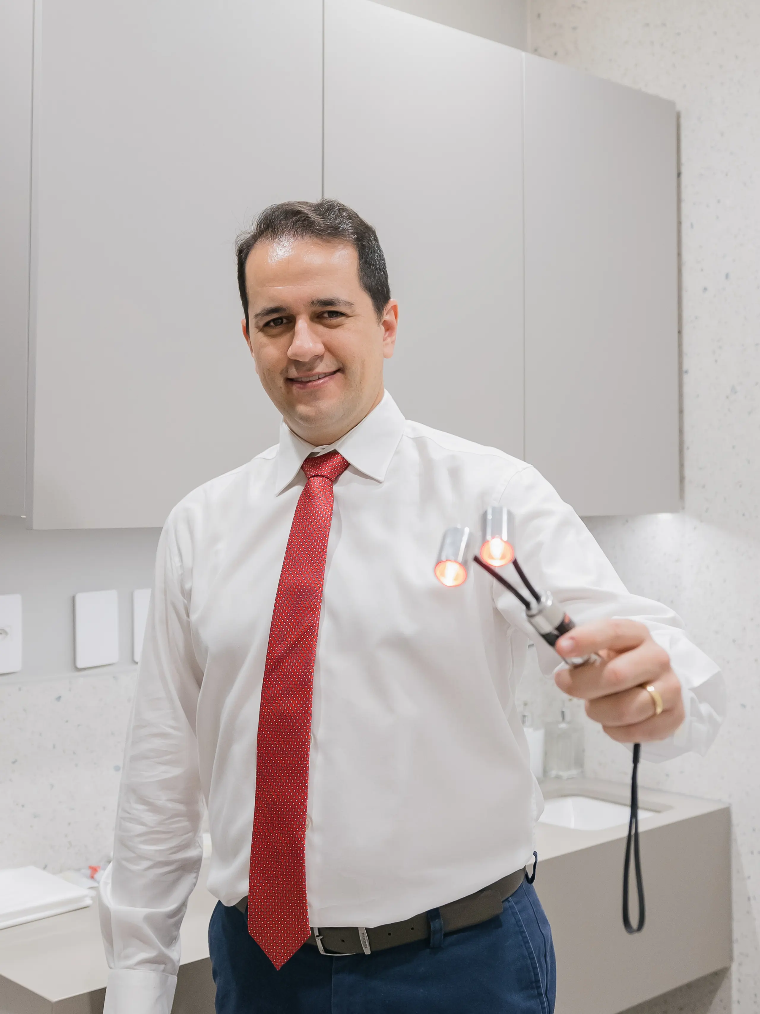 Dr. Lucas Cartafina segurando a fibra óptica de laser usada no tratamento cirúrgico moderno de varizes (endolaser)