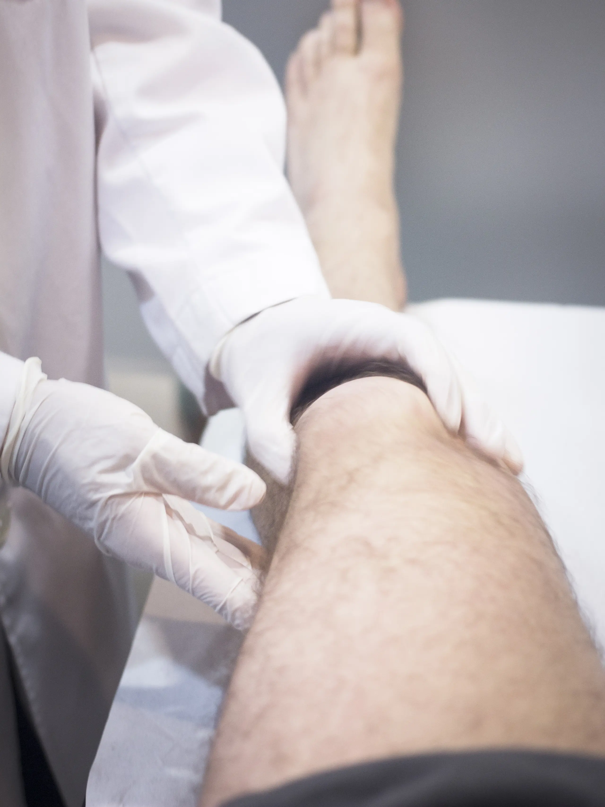 Médico examinando a perna do paciente em consulta para avaliação de lipedema